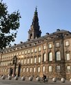 The Danish parliament "Christiansborg" viewed from a frog-eyed perspective with a blue sky in the background.