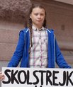 Greta Thunberg holding her original sign saying 'Skolstrejk för klimatet' [School strike for the climate].