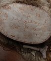 A drum with different signs/symbols drawn onto it.