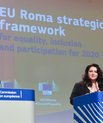 Two women in suits with a Powerpoint presentation entitled EU Roma strategic framework behind