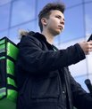 Delivery young man with a pizza box on his back and a mobile phone in his hand